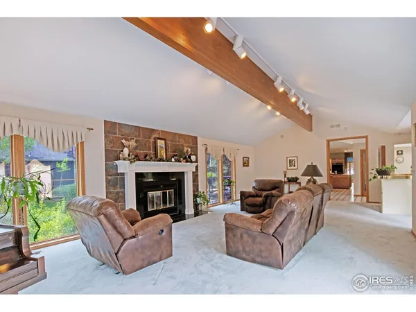 a living room with furniture a fireplace and a large window