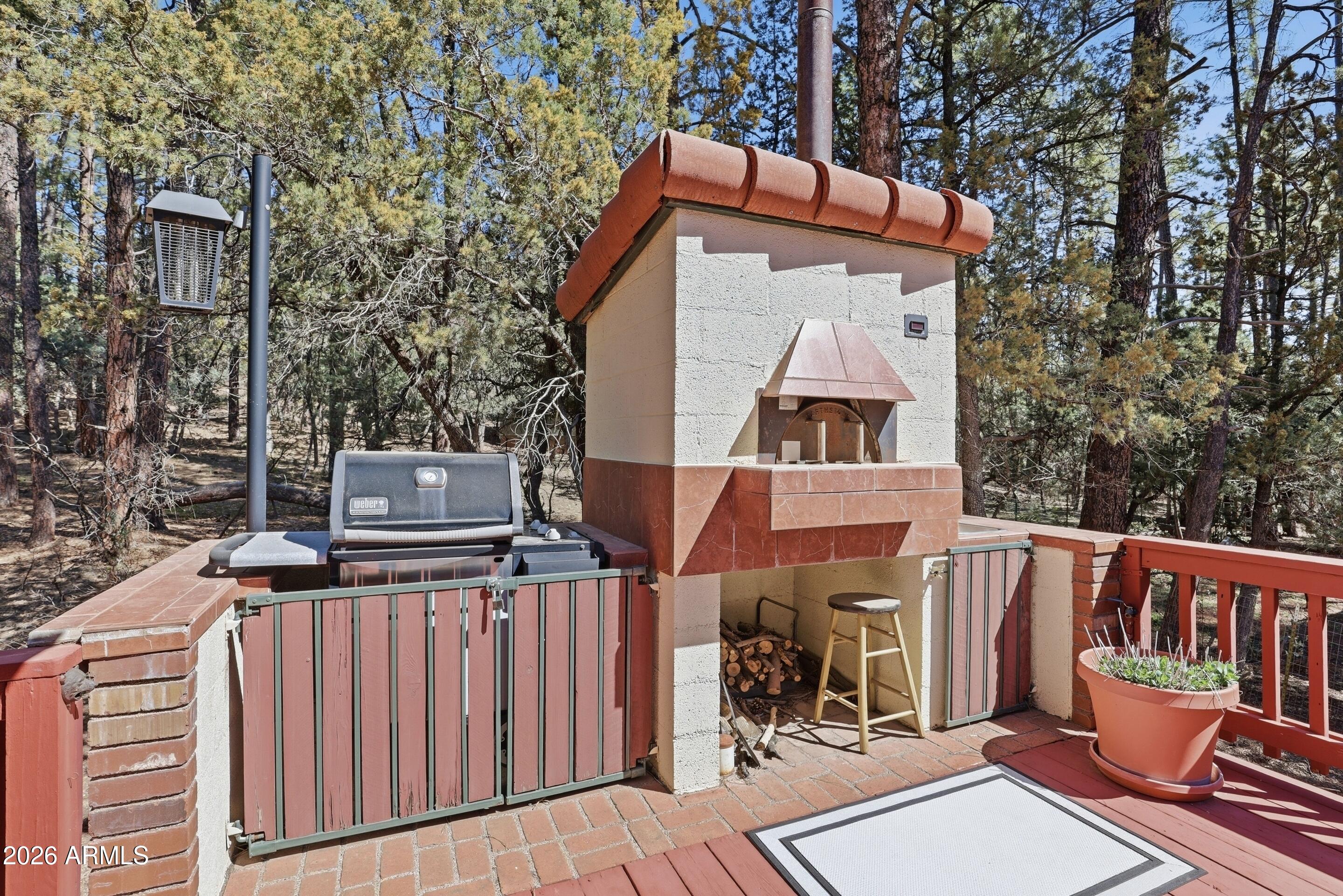 6740 Ridge Road Pine, AZ 85544 - Photo 22 of 35 a view of a patio with table and chairs with wooden floor and fence