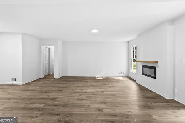 a view of an empty room with a fireplace and a window