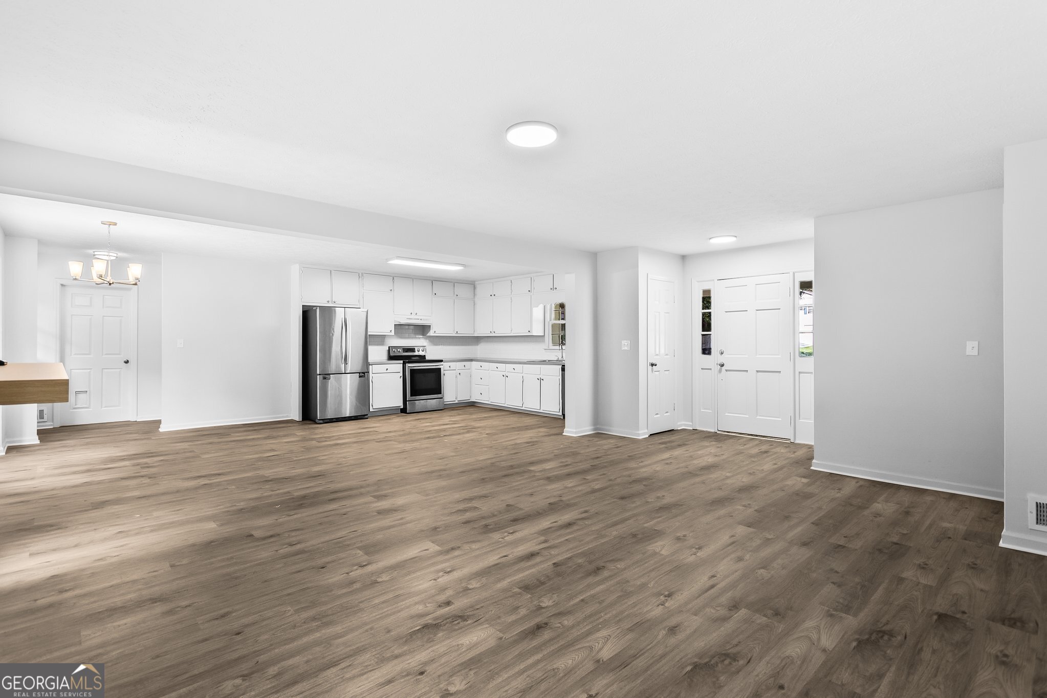 3620 Knoll Crest Trail Buford, GA 30519 - Photo 14 of 47 a view of empty room with wooden floor and kitchen