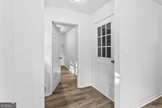 a view of a hallway with wooden floor and closet