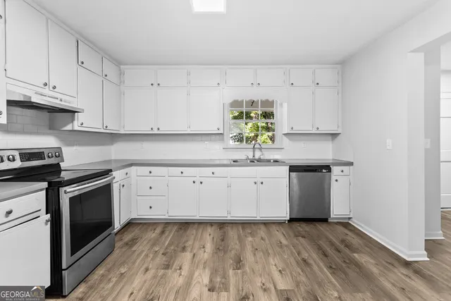 a kitchen with granite countertop white cabinets and white appliances
