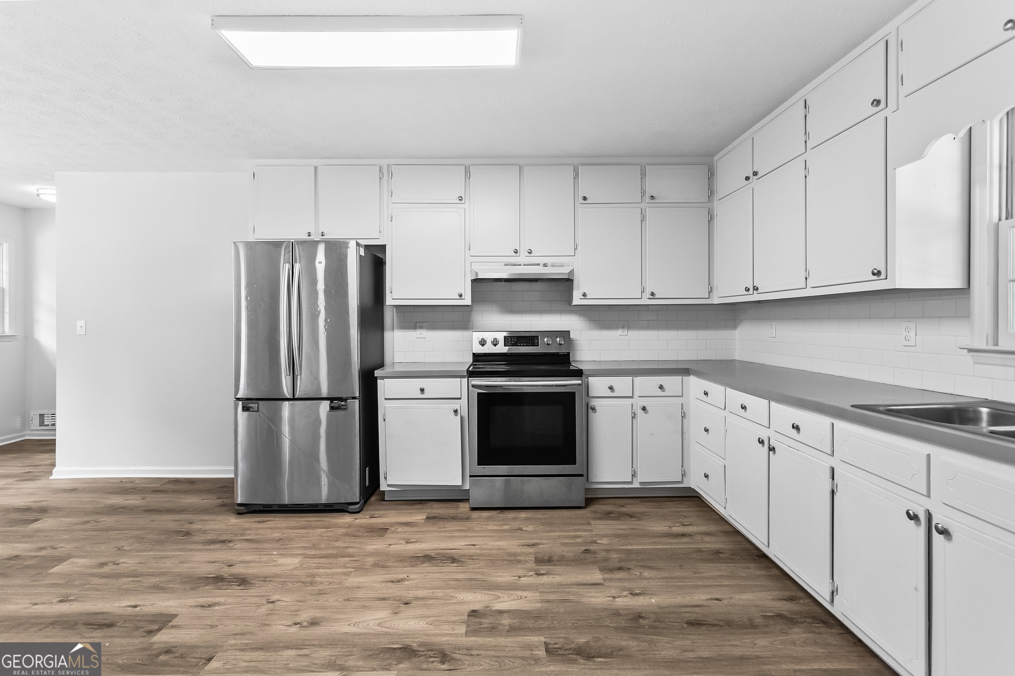 3620 Knoll Crest Trail Buford, GA 30519 - Photo 5 of 47 a kitchen with granite countertop a refrigerator stove and white cabinets