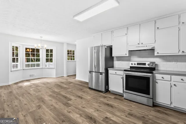 a kitchen with granite countertop a refrigerator stove and microwave
