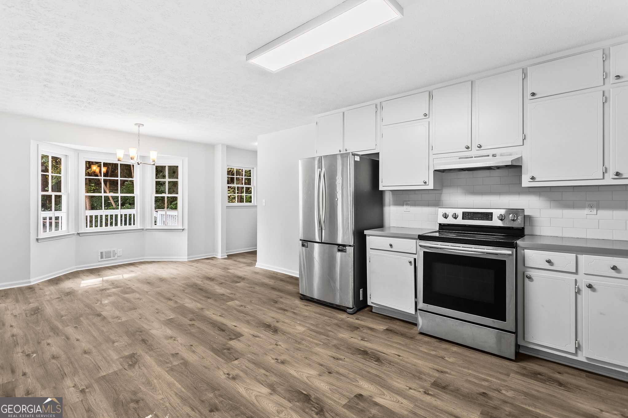 3620 Knoll Crest Trail Buford, GA 30519 - Photo 6 of 47 a kitchen with granite countertop a refrigerator stove and microwave