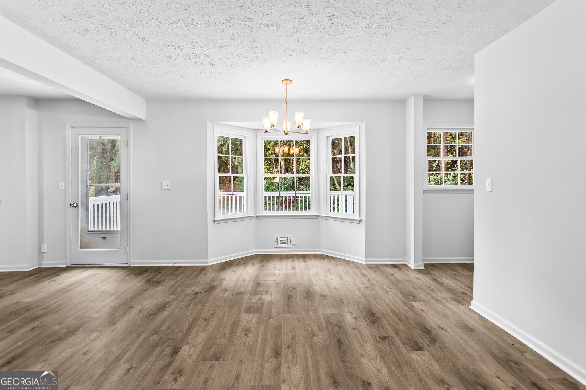3620 Knoll Crest Trail Buford, GA 30519 - Photo 9 of 47 a view of an empty room with wooden floor and a window