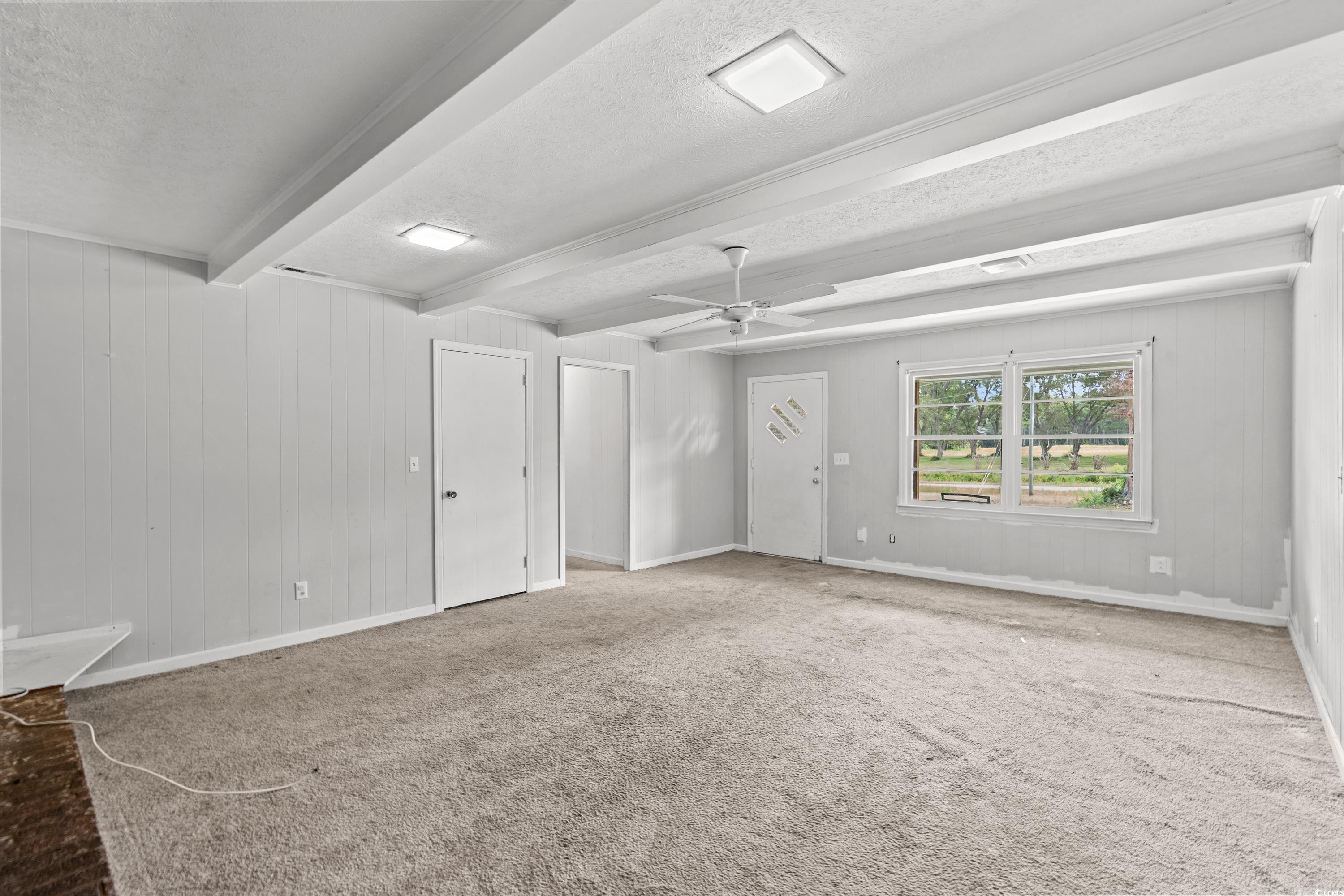 476 Live Oak Church Road Loris, SC 29569 - Photo 8 of 39 Carpeted empty room featuring ceiling fan, beam ce