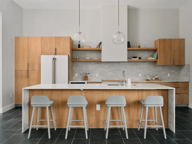 a kitchen with a dining table chairs and a refrigerator