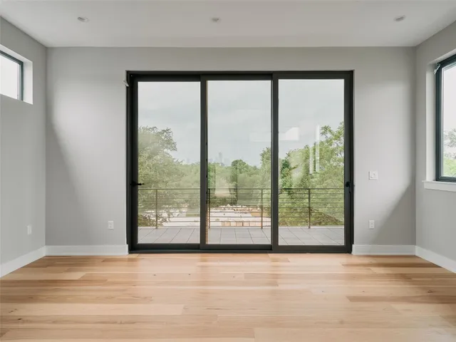 a view of a room with wooden floor and a floor to ceiling window