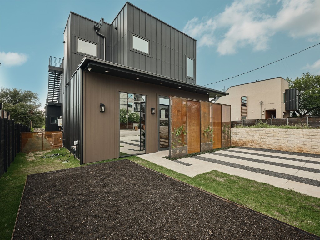 412 Kemp Street Austin, TX 78741 - Photo 31 of 37 Back of house featuring a fenced backyard and board and batten siding