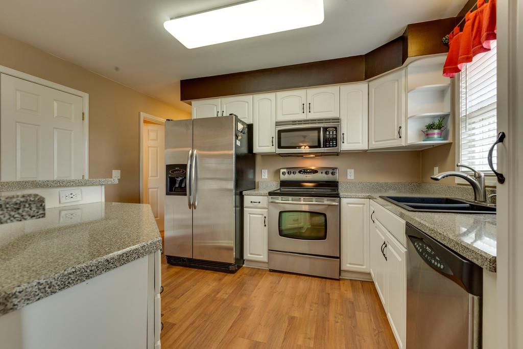 3636 Mahlon Moore Road Spring Hill, TN 37174 - Photo 7 of 22 a kitchen with granite countertop a sink cabinets stainless steel appliances and a window