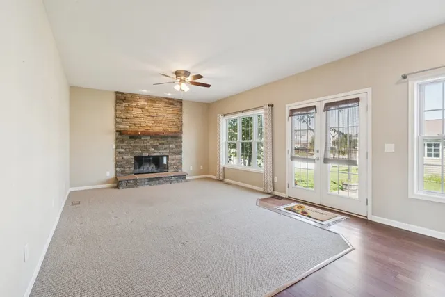 an empty room with windows and fireplace