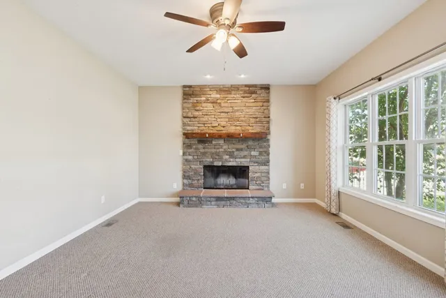 a view of a livingroom with a fireplace and window