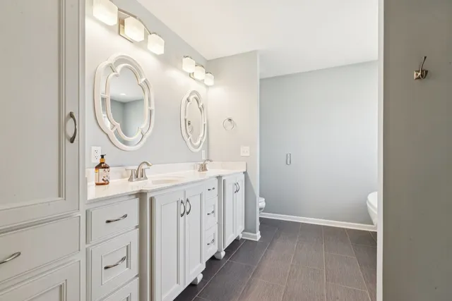 a spacious bathroom with a double vanity sink and a mirror