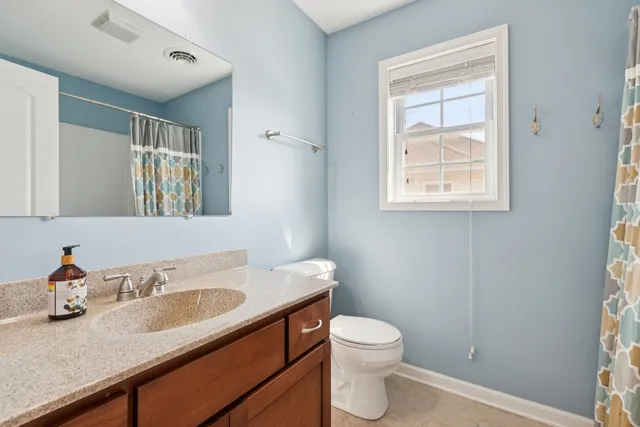 a bathroom with a granite countertop toilet sink and mirror