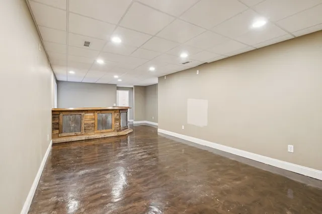 an empty room with wooden floor and natural light