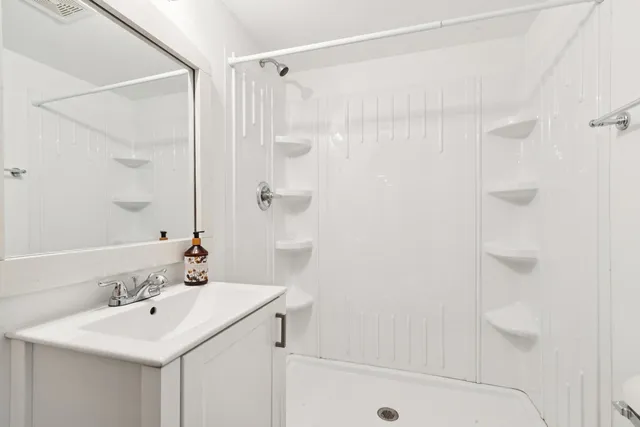 a bathroom with a sink a shower and a mirror