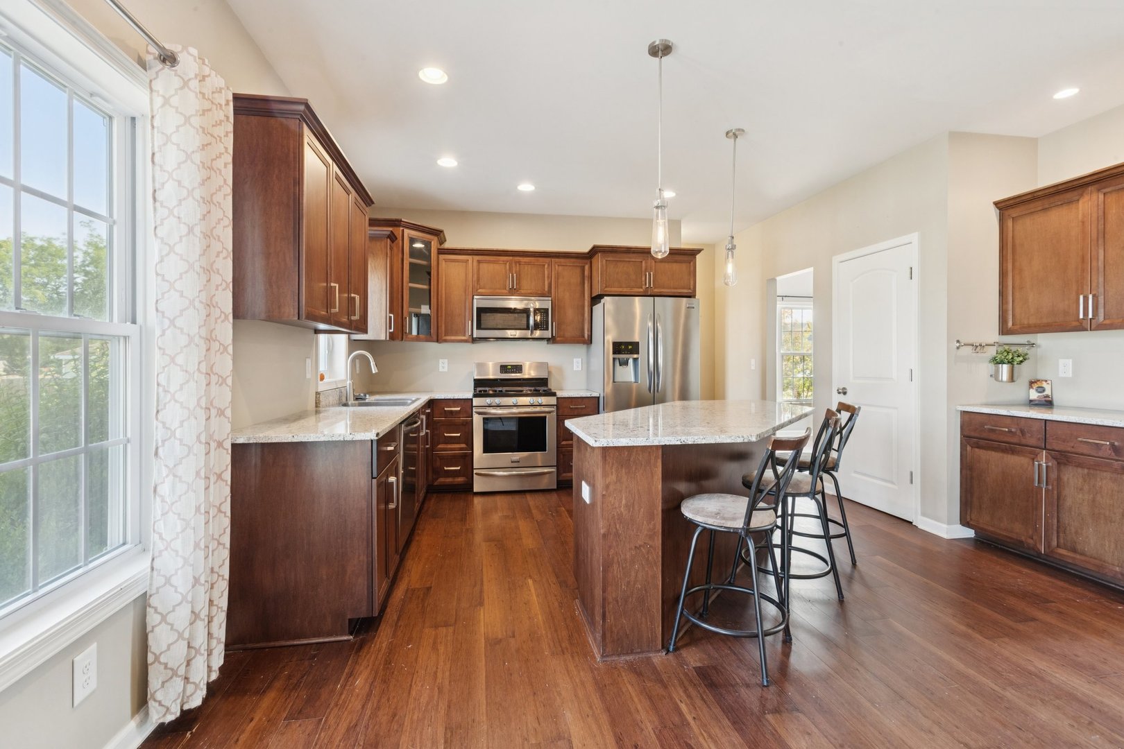 345 South Calkey Street Diamond, IL 60416 - Photo 9 of 50 a kitchen with stainless steel appliances a dining table chairs and wooden floor