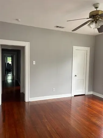 a view of an empty room with wooden floor