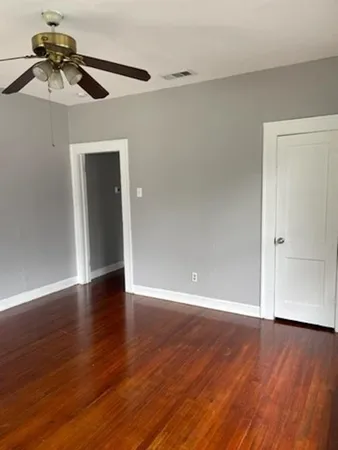 a view of an empty room with wooden floor