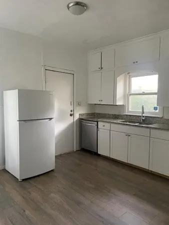 a kitchen with cabinets stainless steel appliances a sink and a window