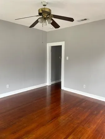 a view of an empty room with wooden floor