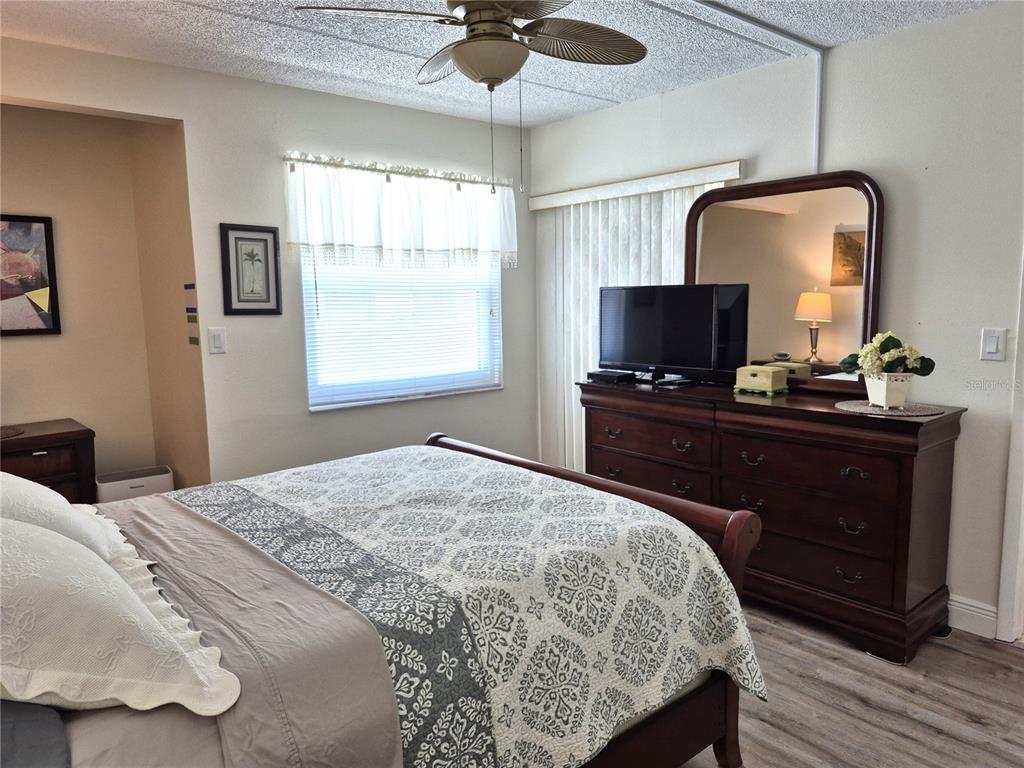 107 Windward Place, Unit 107 Oldsmar, FL 34677 - Photo 20 of 34 a bedroom with a bed and a flat tv screen on the dresser