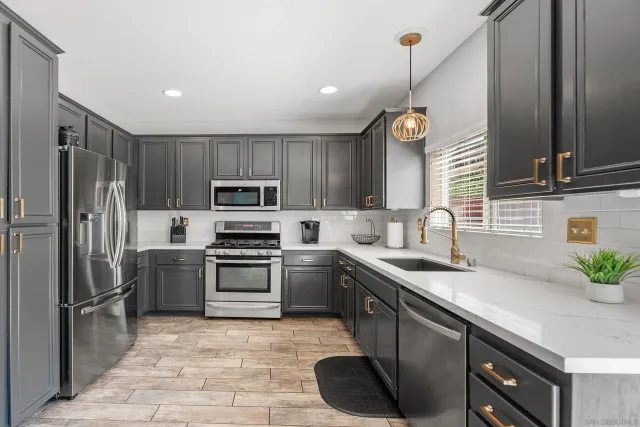 a kitchen with kitchen island granite countertop a sink stainless steel appliances and cabinets