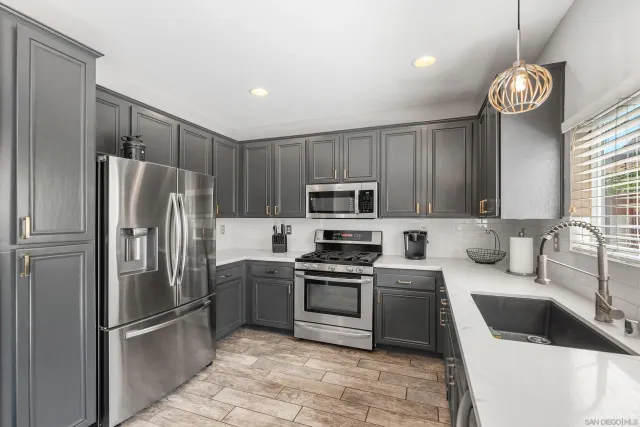 a kitchen with stainless steel appliances granite countertop a sink a stove a refrigerator and island