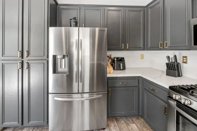 a kitchen with stainless steel appliances a refrigerator and cabinets