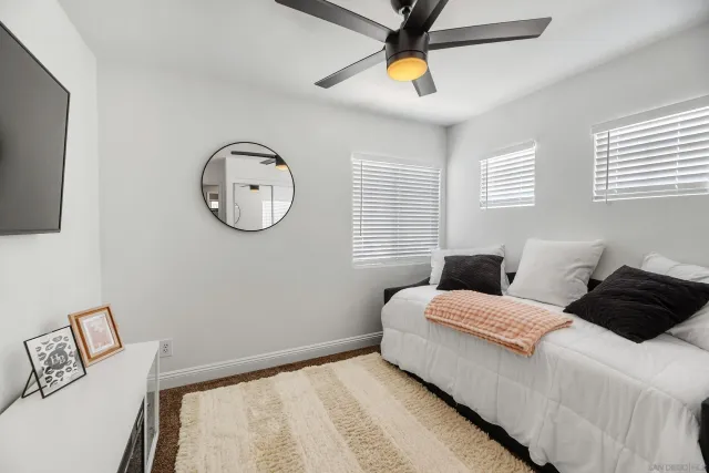 a bedroom with a bed a window and a chandelier