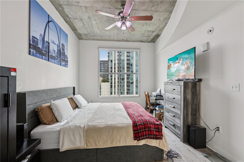 250 Pharr Road Northeast, Unit 1005 Atlanta, GA 30305 - Photo 11 of 25 a bedroom with furniture and a flat screen tv