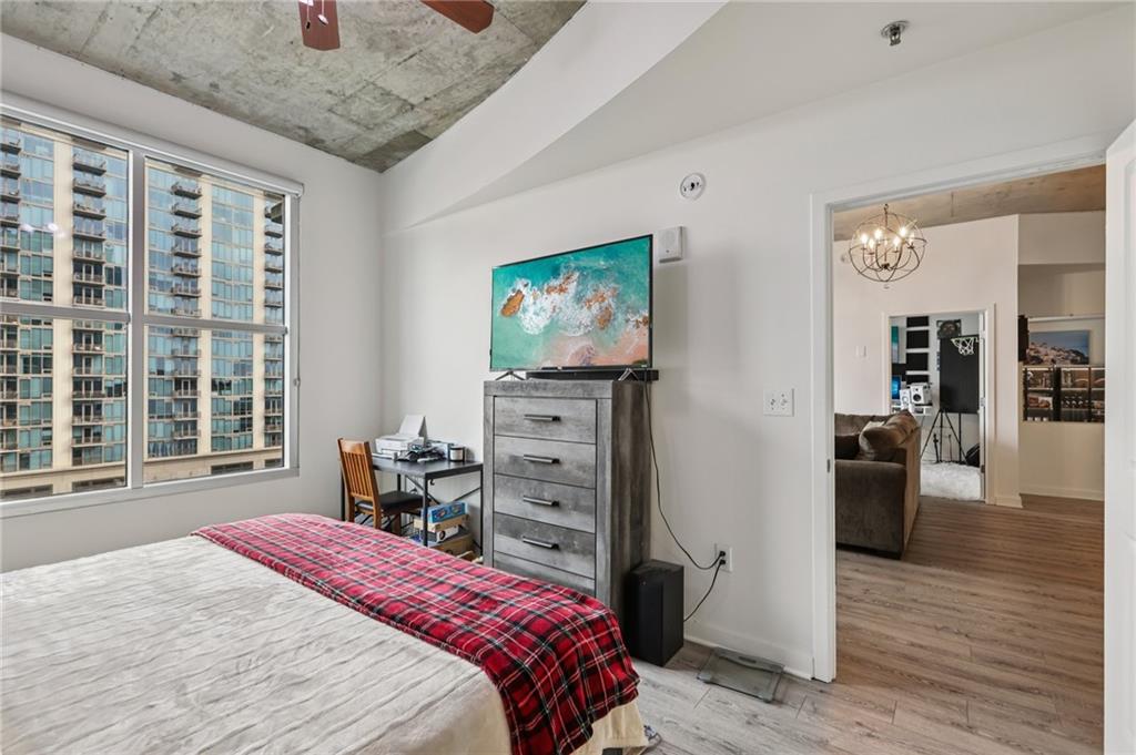 250 Pharr Road Northeast, Unit 1005 Atlanta, GA 30305 - Photo 12 of 25 a bedroom with a bed and wooden floor