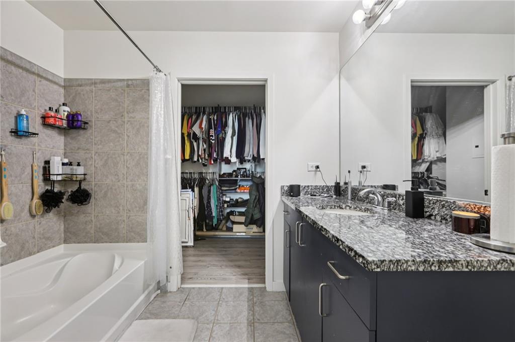 250 Pharr Road Northeast, Unit 1005 Atlanta, GA 30305 - Photo 13 of 25 a bathroom with a granite countertop sink mirror and a bathtub
