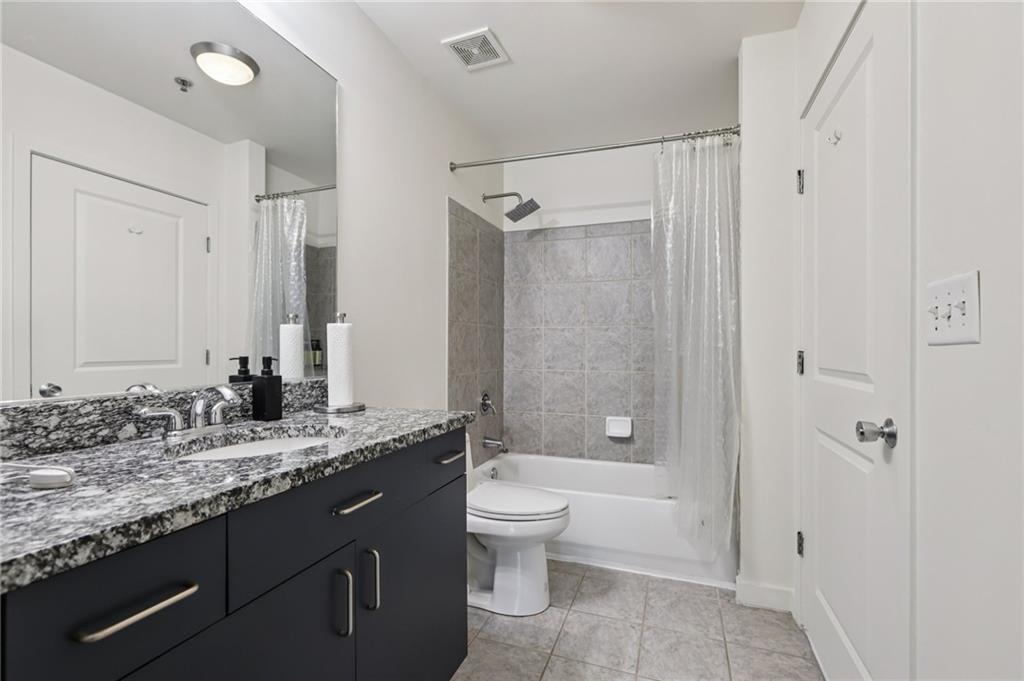 250 Pharr Road Northeast, Unit 1005 Atlanta, GA 30305 - Photo 16 of 25 a bathroom with a granite countertop sink toilet and shower