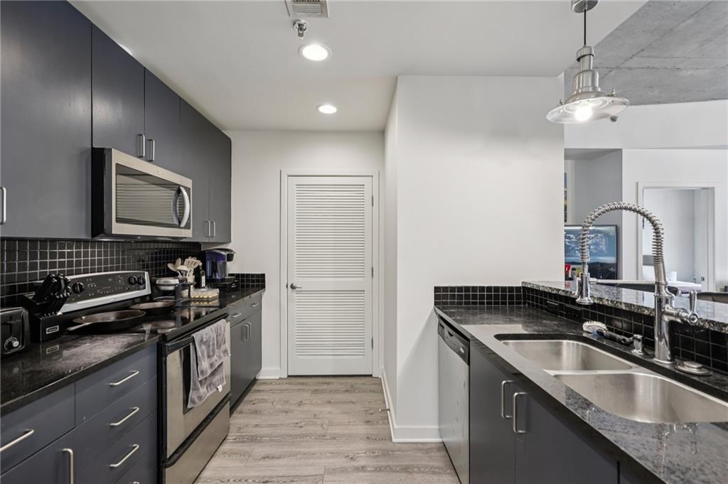250 Pharr Road Northeast, Unit 1005 Atlanta, GA 30305 - Photo 4 of 25 a kitchen that has a sink and a stove