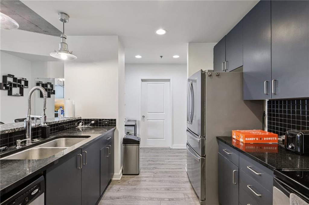 250 Pharr Road Northeast, Unit 1005 Atlanta, GA 30305 - Photo 5 of 25 a kitchen with stainless steel appliances granite countertop a sink stove and refrigerator