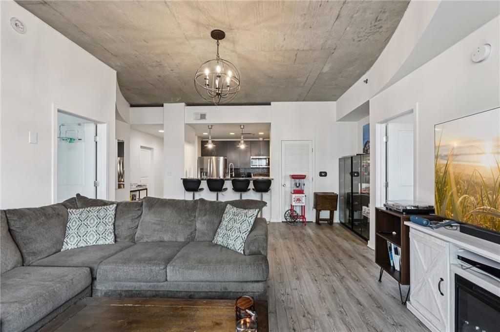 250 Pharr Road Northeast, Unit 1005 Atlanta, GA 30305 - Photo 9 of 25 a living room with furniture kitchen view and a chandelier