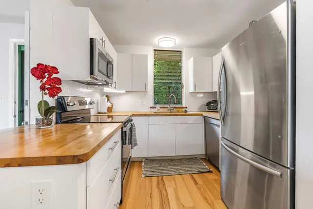 a kitchen with granite countertop a sink stainless steel appliances and cabinets