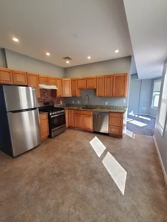 a kitchen with stainless steel appliances granite countertop a refrigerator and a stove top oven