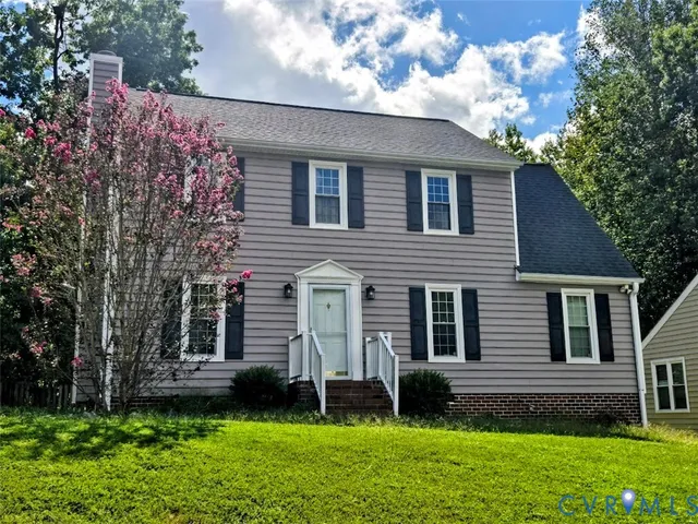 a brick house with a large tree in front of it