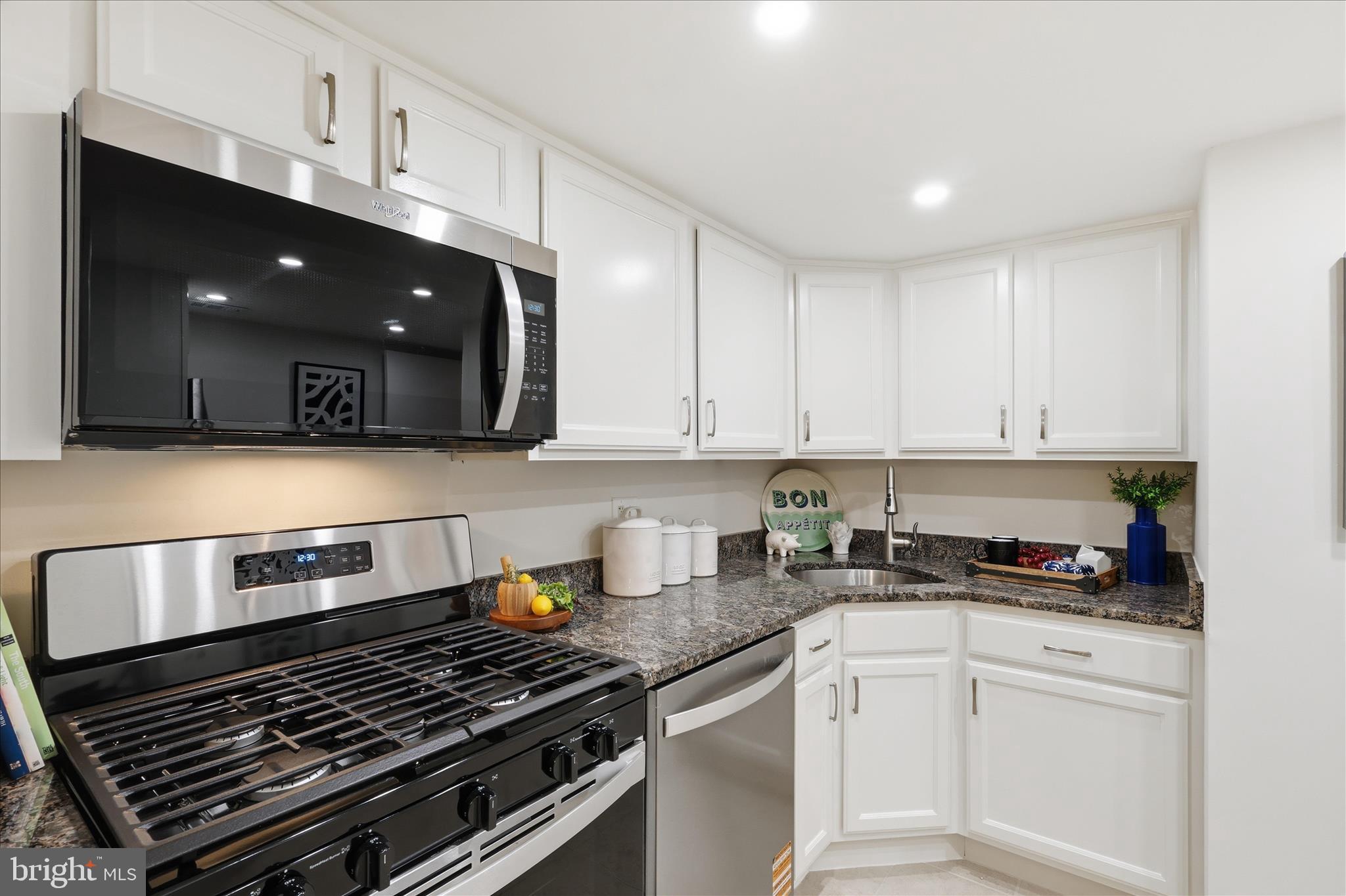 1540 Northgate Square, Unit 21B Reston, VA 20190 - Photo 4 of 24 a kitchen with a stove and white cabinets
