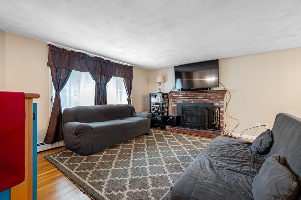 179 Beaman Road Princeton, MA 01541 - Photo 7 of 34 a living room with furniture a flat screen tv and a fireplace