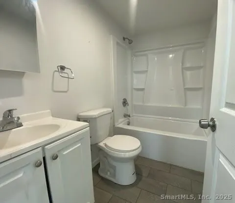 a white toilet sitting next to a bath tub
