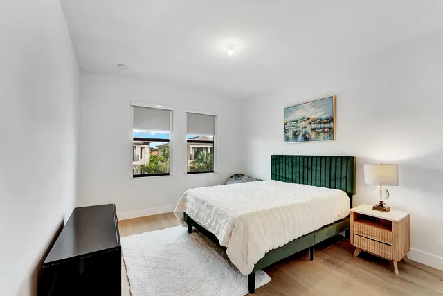 a bedroom with a bed and painting on the wall