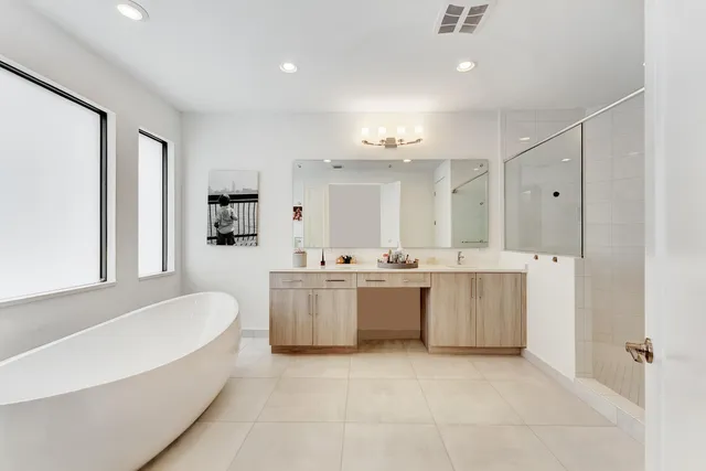 a large white bathroom with a large tub sink vanity and granite