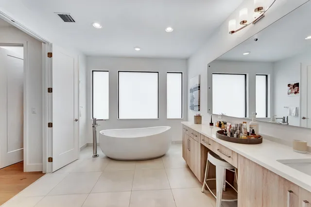 a bathroom with a bathtub sink vanity and mirror