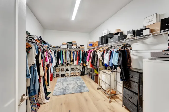 a view of walk in closet with clothes