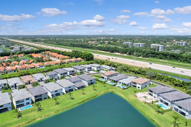 an aerial view of a city with lots of residential buildings ocean and mountain view in back