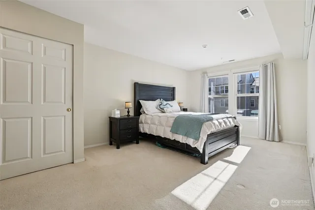 a bedroom with a bed lamp closet and window